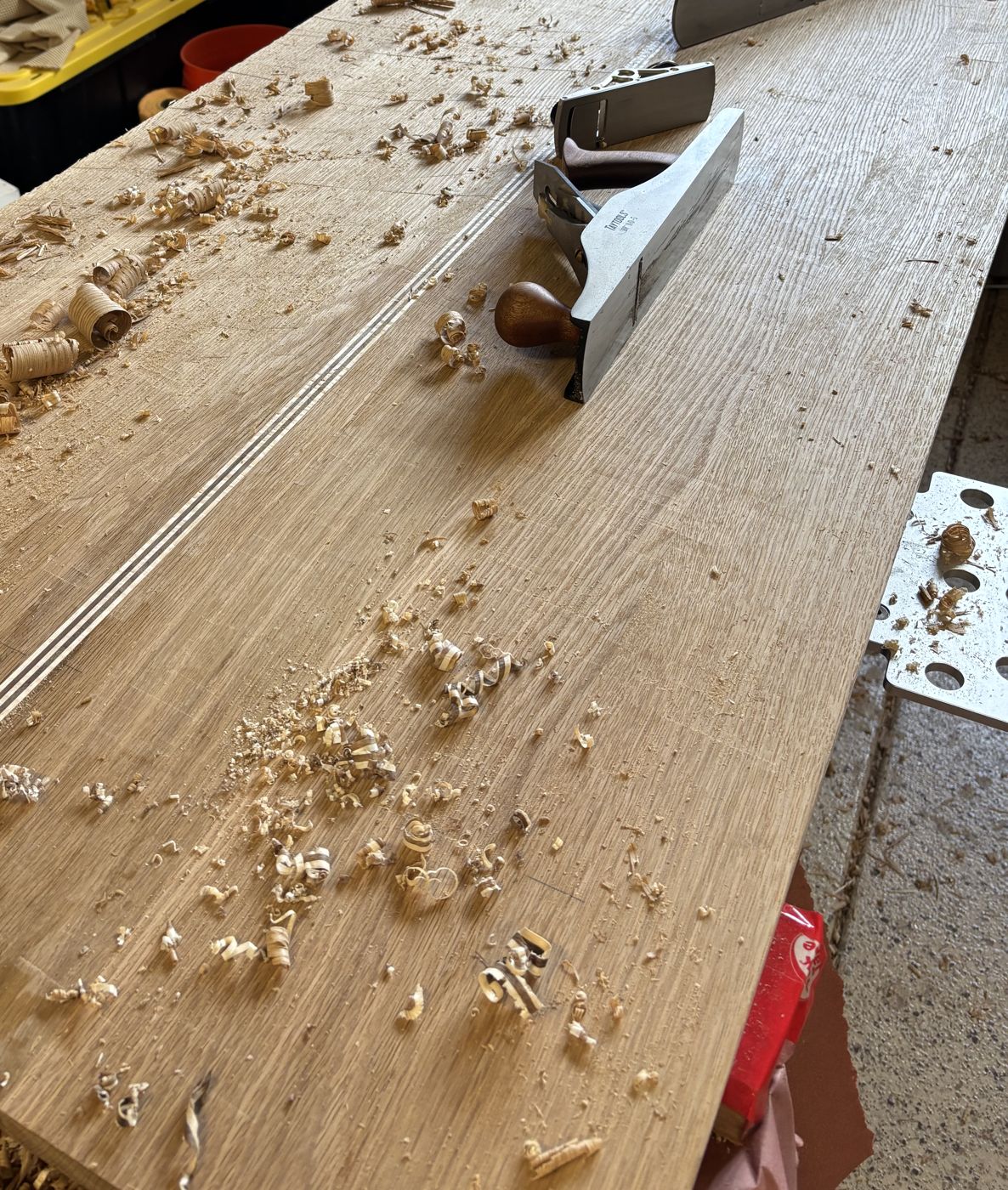 Hand planes resting on a white oak top covered in curled shavings